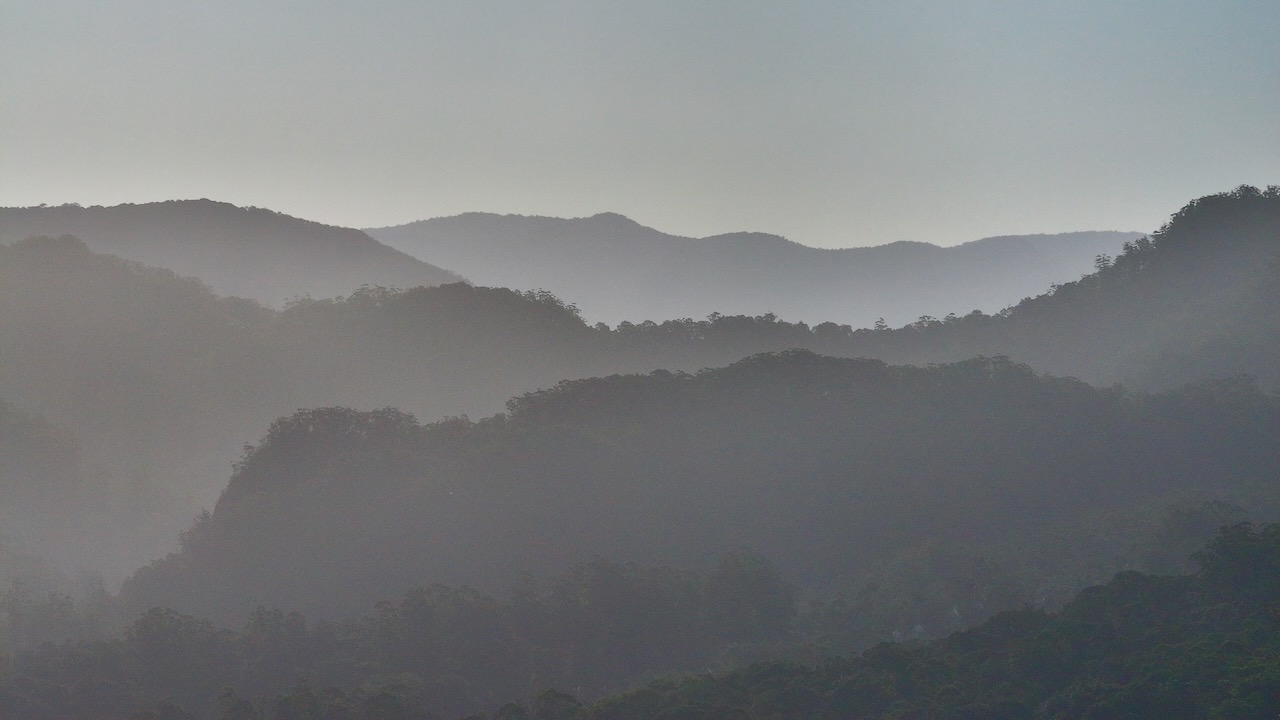 Layered mountain ranges in morning mist